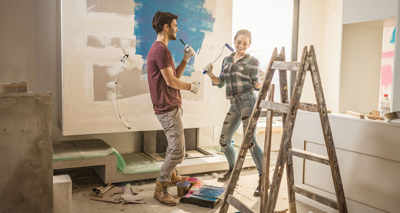 Young couple painting new house